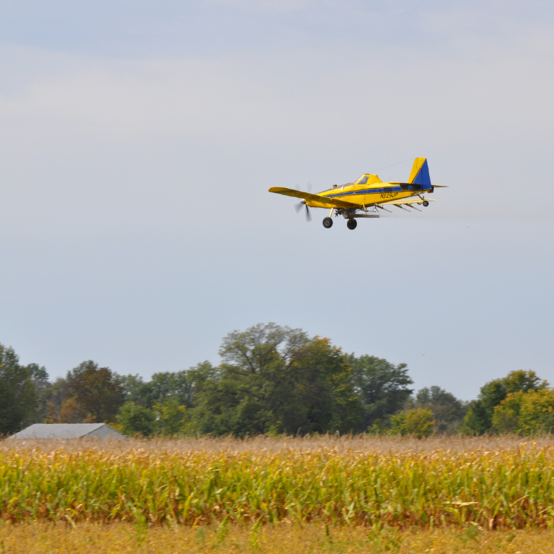 A plane flying over an agriculture field